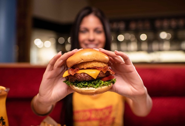 Woman Holding Cheeseburger with Arms Extended Toward Camera