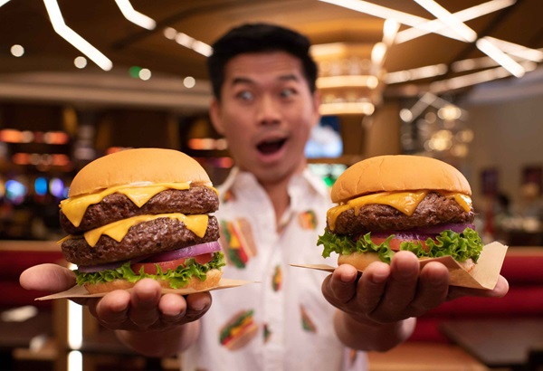 Man Wearing Cheeseburger Shirt Holding a Burger in Each Hand